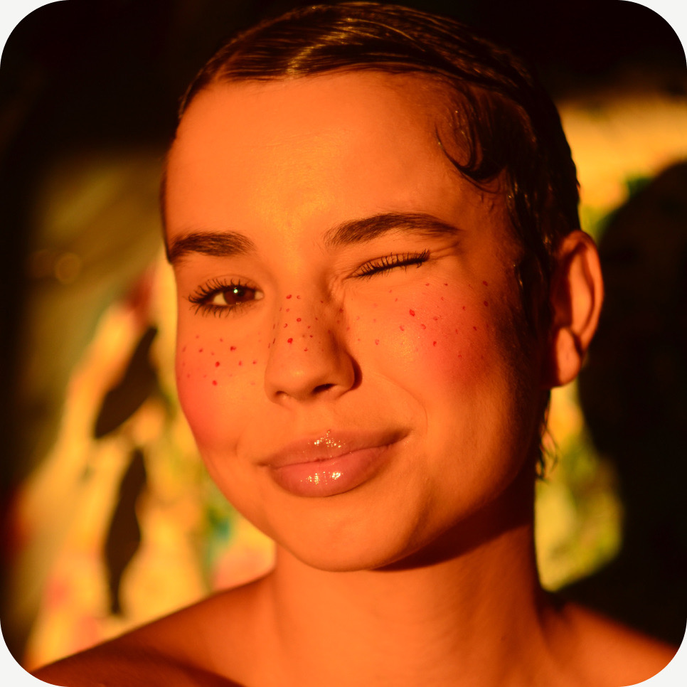 Portrait of Maja Korzeniewska, winking, in warm orange light